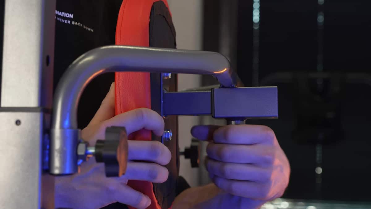 Man adjusting the backrest on the relife power tower with the simple pull and turn knob screws.