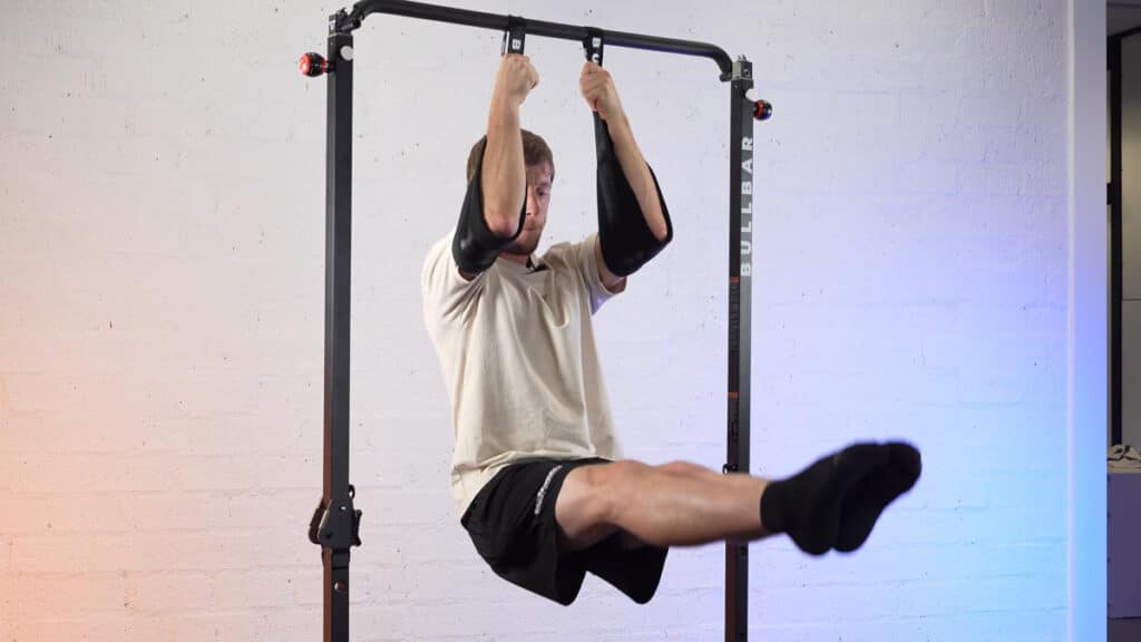 Man in white shirt doing leg raises with his elbows cradles in the bullbar ab straps which are suspended from a bullbar 2.0 extended pull-up bar.