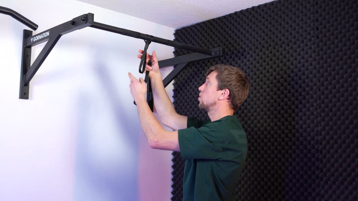 Man attaching kensui swissies rotator bands to the gornation pull-up bar.
