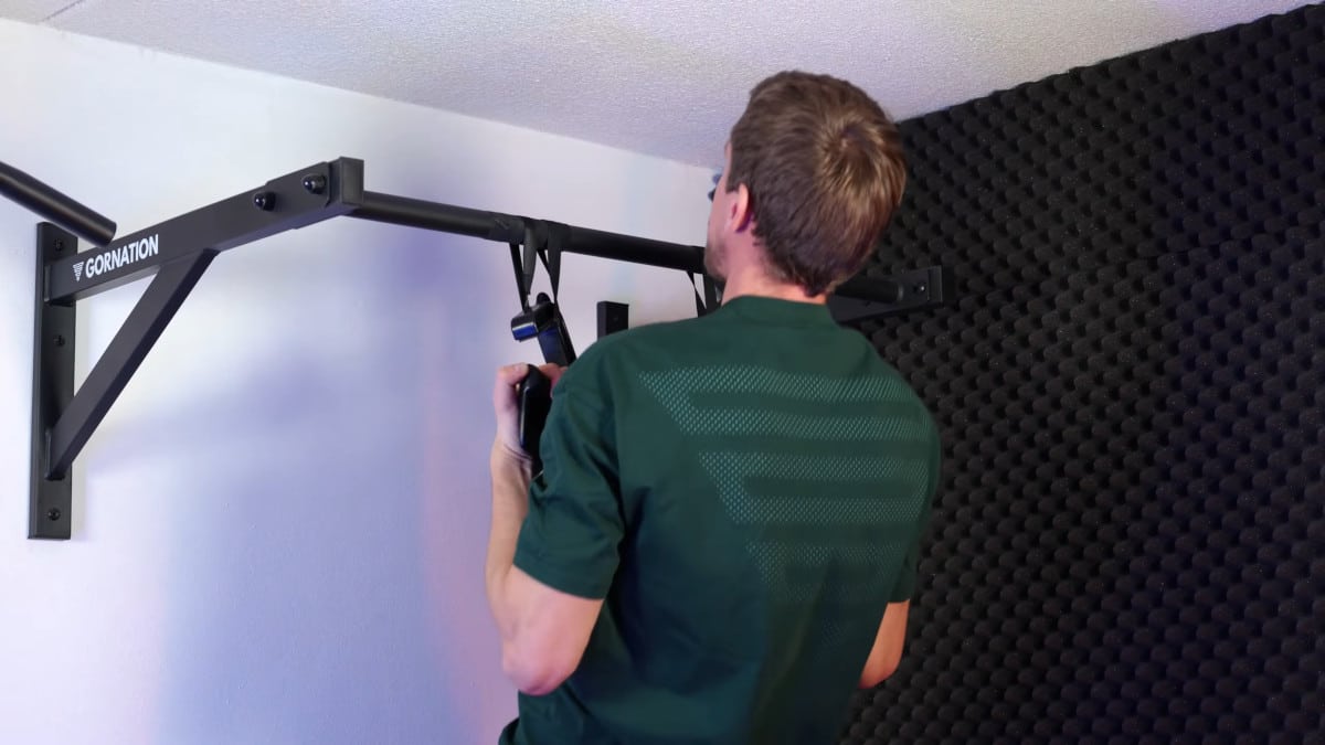 Man doing rotating pull-ups on kensui swissies with the rotator bands.