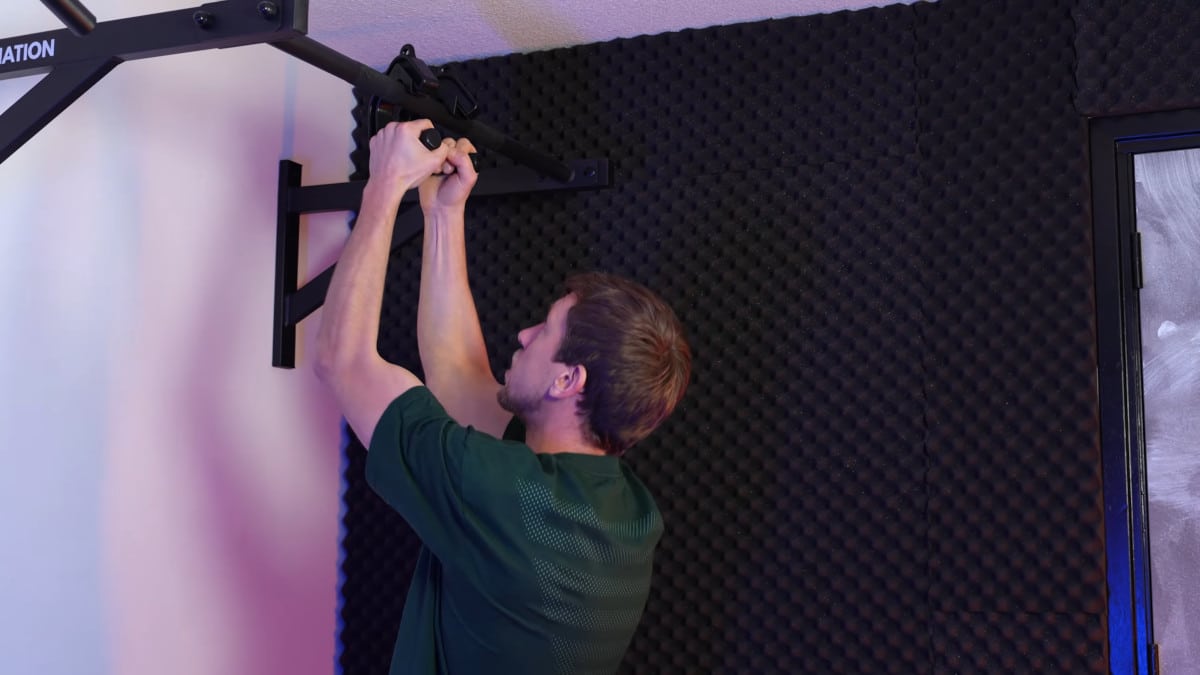Man in green shirt doing pull-ups on the kensui swissies v2.
