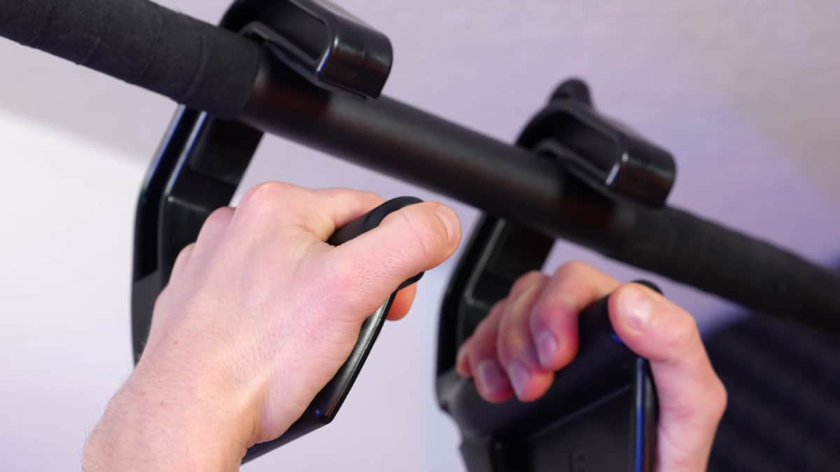 Close up of a man doing pull-ups on the kensui swissies v2 max, showing the ergonomic thumb rest and flaps.