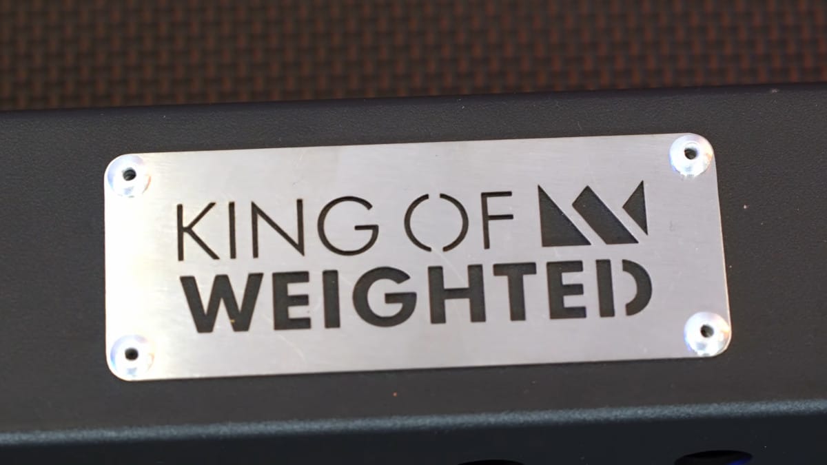 Close up of the metal plate on the feet of the king of weighted adjustable dip station depicting the company logo.