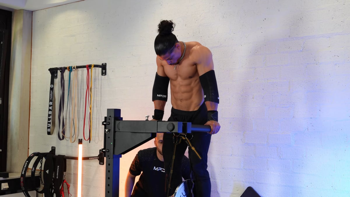 Jurvin Valdez behind a king of weighted adjustable dip station in perparation of doing an exercise.