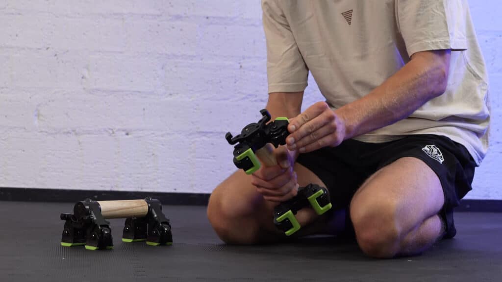 Man in white shirt changing a duonamic axis from core wheel to parallette mode.