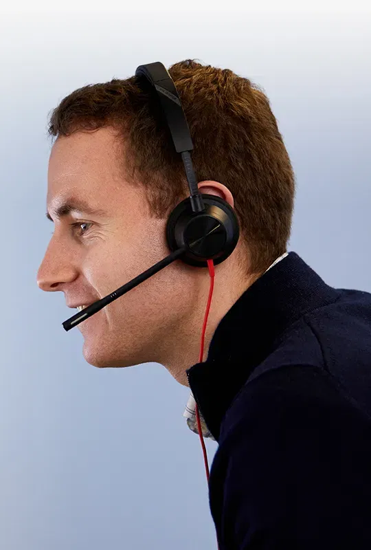 A man in profile wearing a hands-free headset