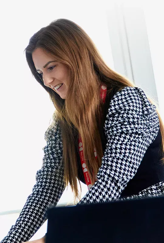 A woman wearing an Oury Clark lanyard typing