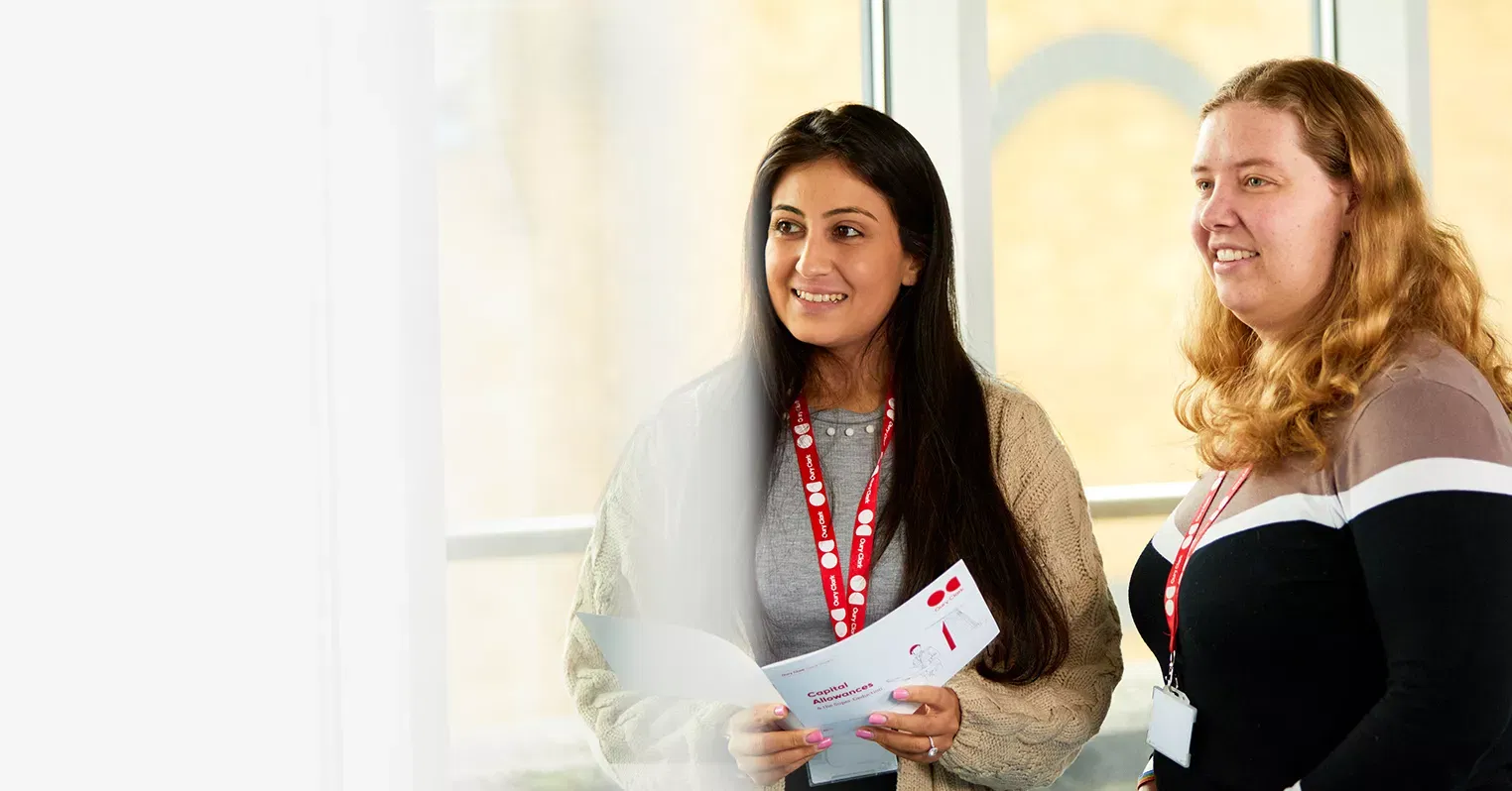 A photo of two women smiling and wearing Oury Clark lanyards