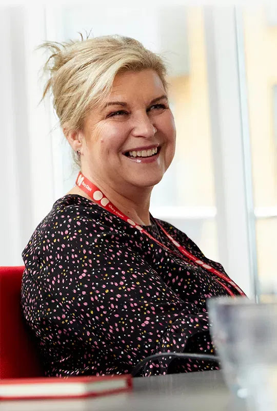 Two smiling women wearing Oury Clark lanyards