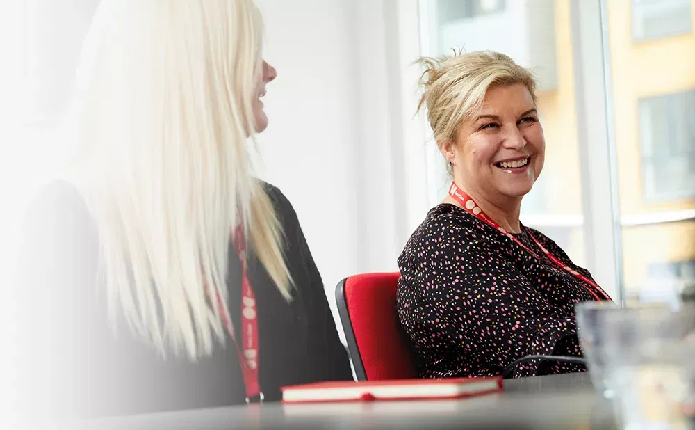 A photo of two women smiling and weating Oury Clark lanyards