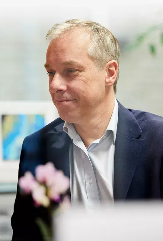 A man in an office wearing a blazer and shirt