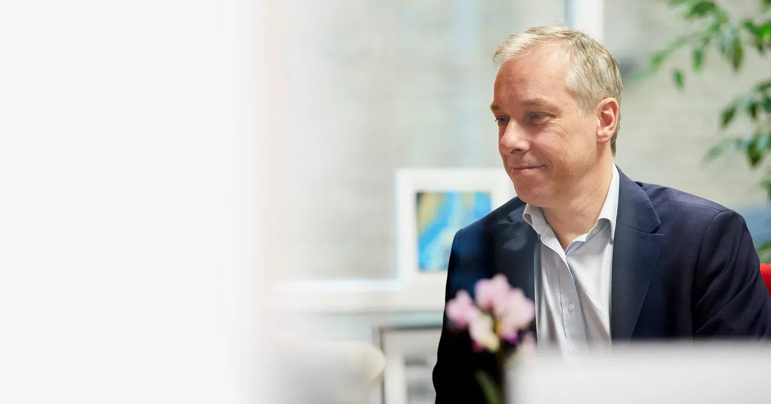 A man in an office wearing a blazer and shirt