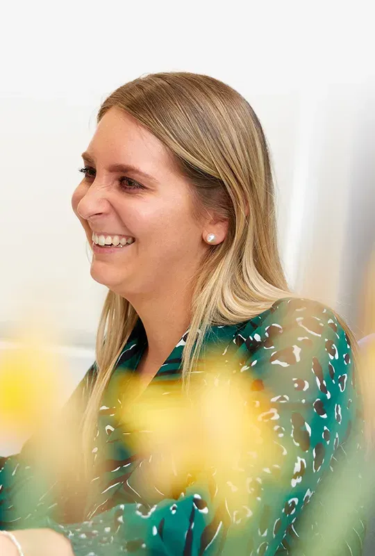 A laughing woman in a green blouse