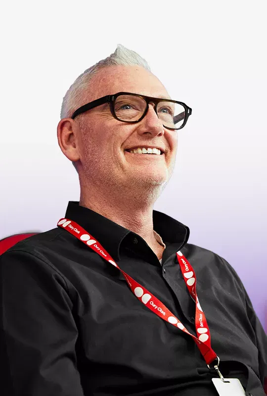 A smiling man in glasses wearing an Oury Clark lanyard