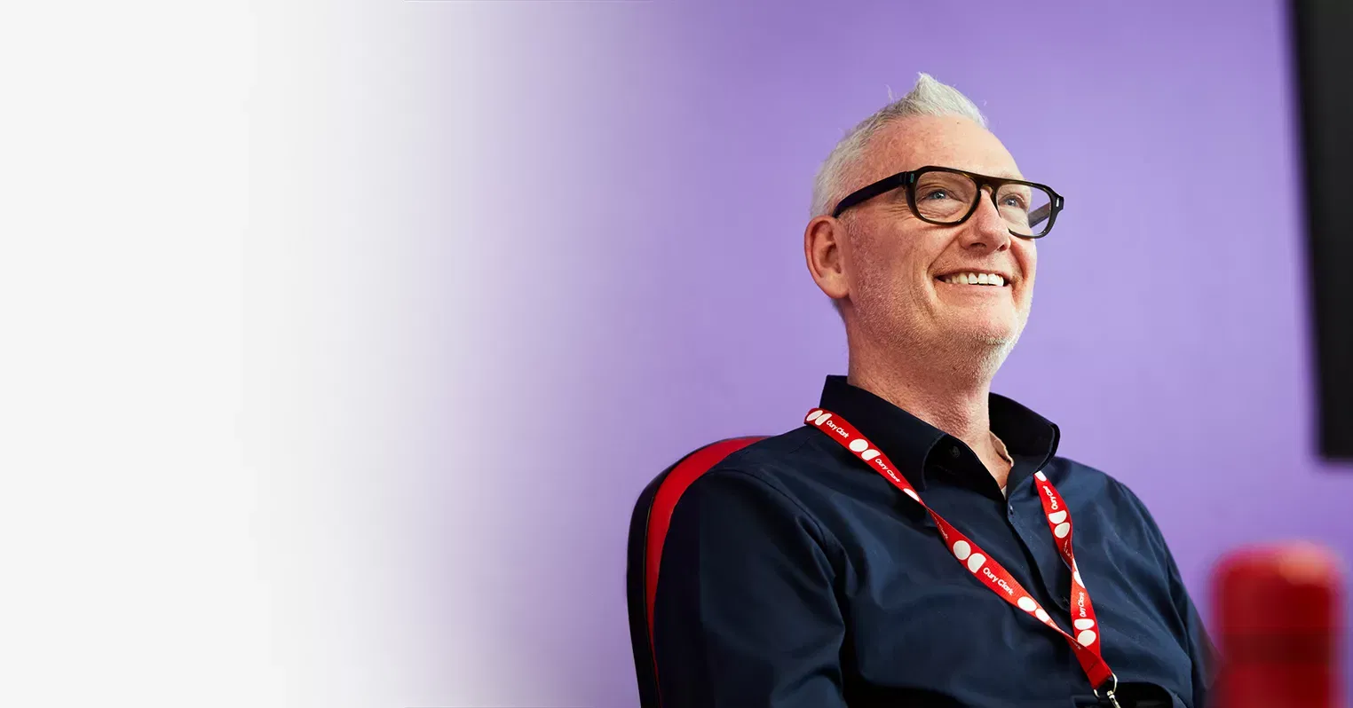 A smiling man in glasses wearing an Oury Clark lanyard
