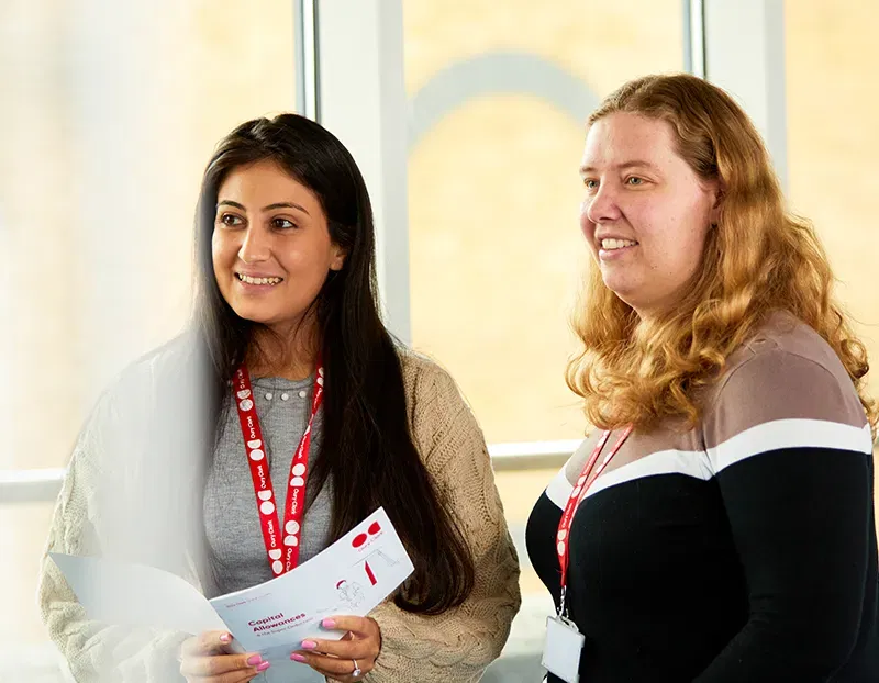 A photo of two women smiling and wearing Oury Clark lanyards