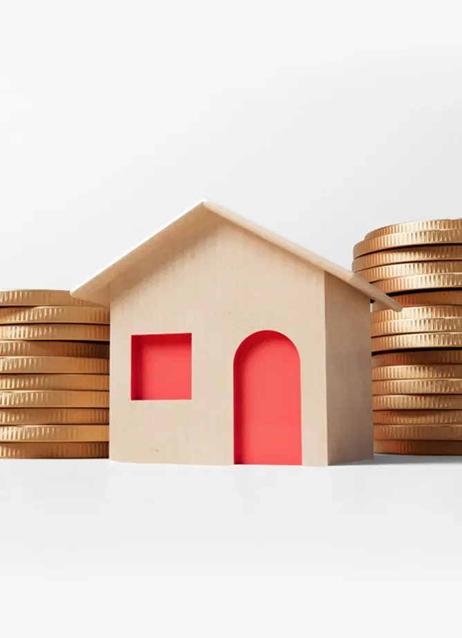 A toy house with a door and window in the middle of two stacks of golden coins