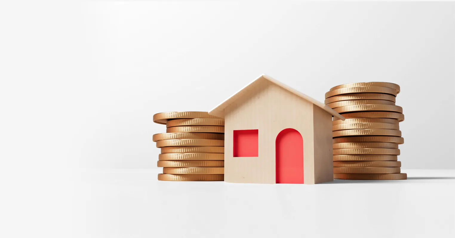 A toy house with a door and window in the middle of two stacks of golden coins