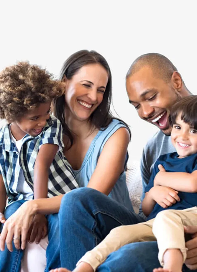 A photo of a family with a mum and dad and two small children, all of them laughing