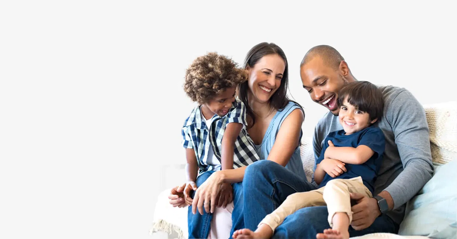 A photo of a family with a mum and dad and two small children, all of them laughing
