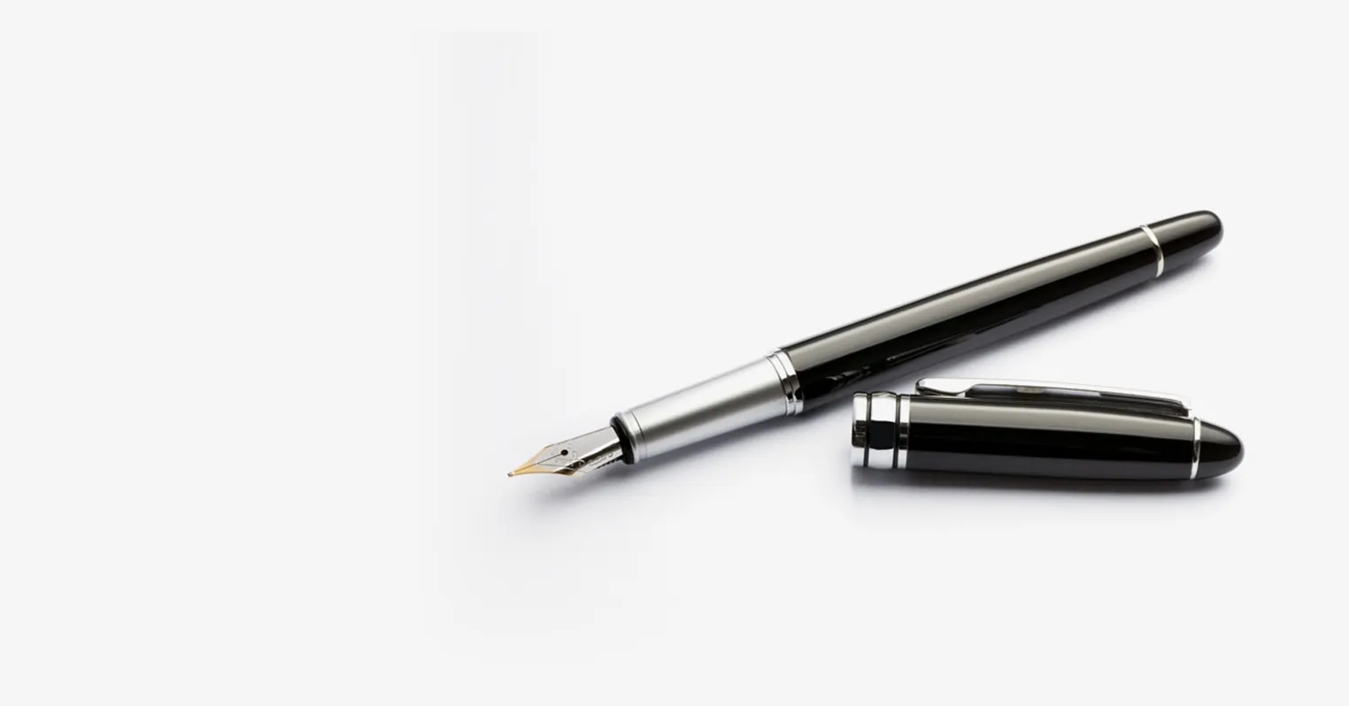 A photo of a black and silver fountain pen, its lid resting next to it
