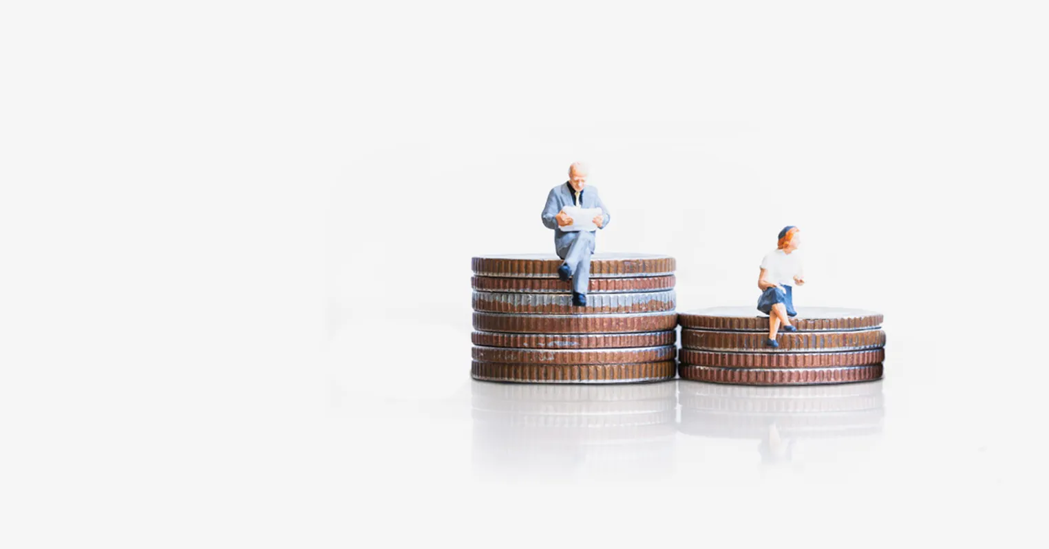 Two different sized piles of coins, with toy figures on a man sitting on the taller one, a woman sat on the smaller one