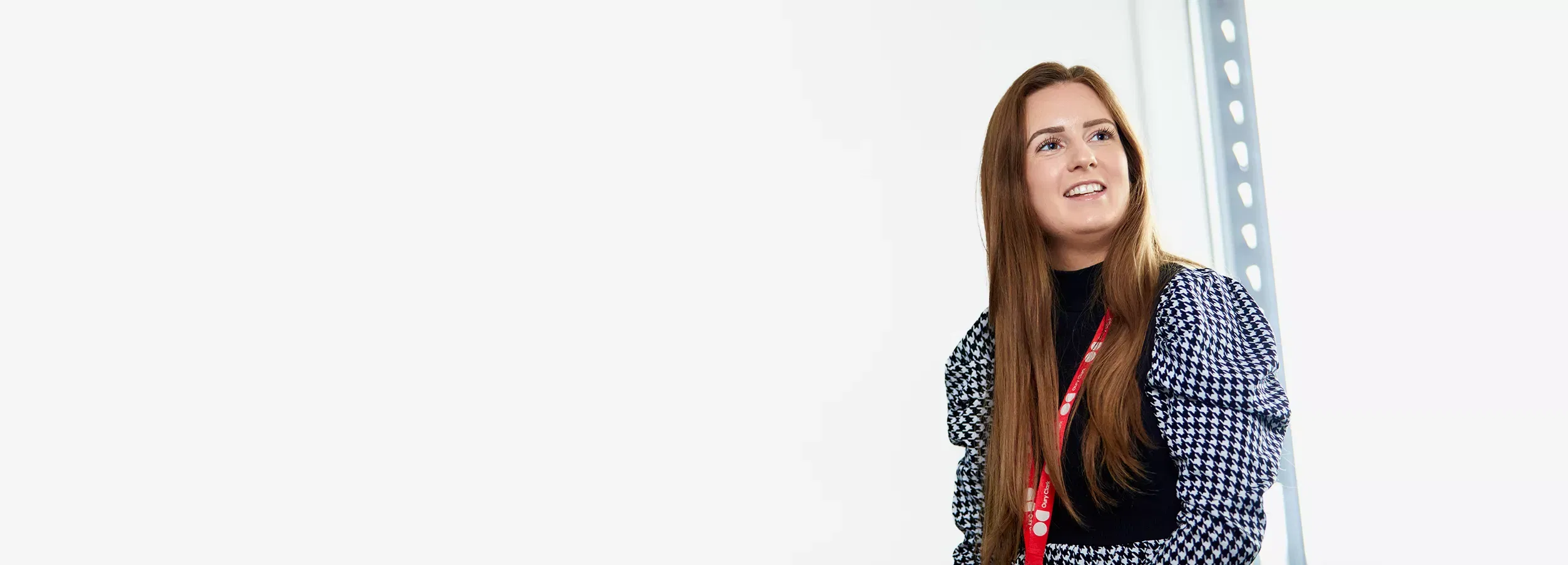 A photo of a smiling woman wearing an Oury Clark lanyard