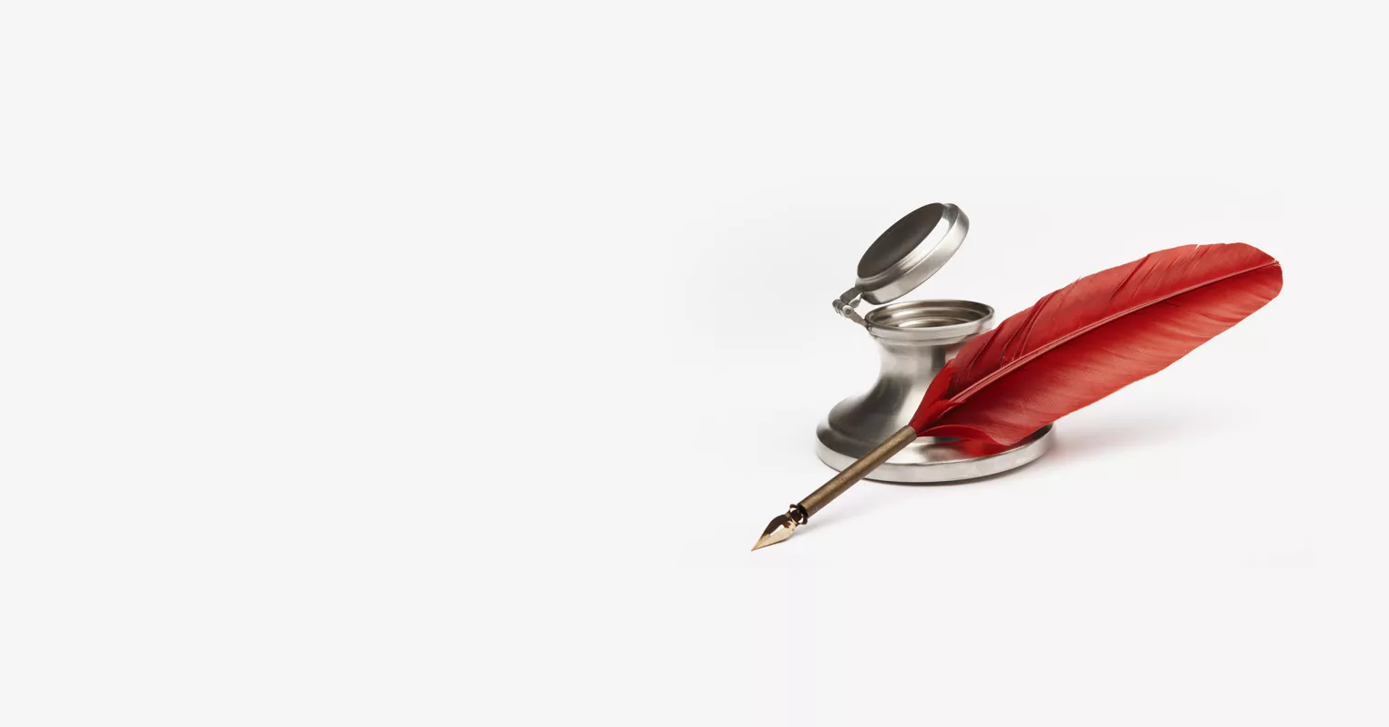 An ink pot with red-feathered quill pen