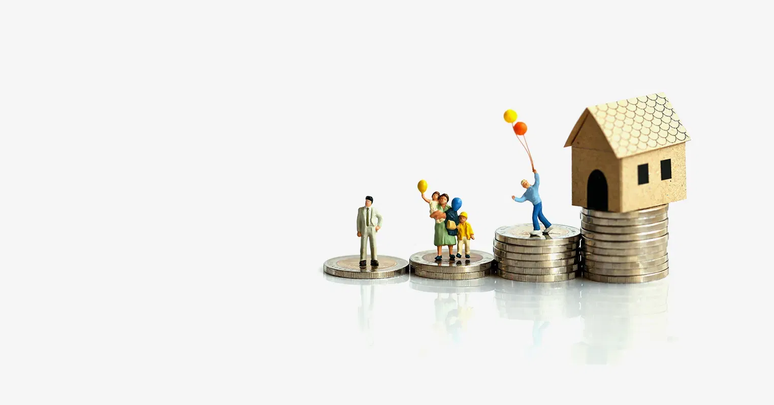 4 different sized piles of coins. The largest on the right has a small toy house on top, the others have a variety of toy figures