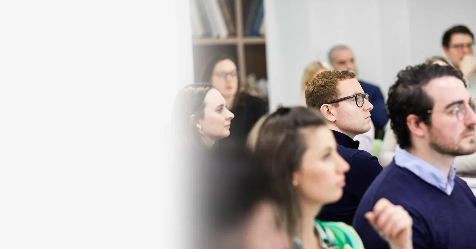 Photo with a blurred left-hand side, then the right side showing a group of people watching something