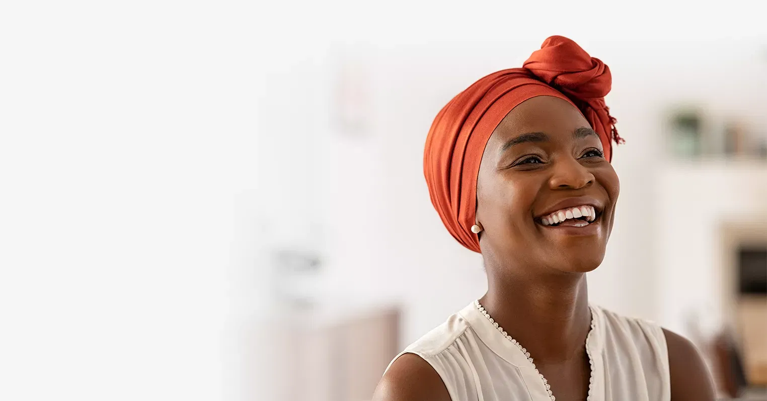 Photo of a woman wearing a head wrap and smiling