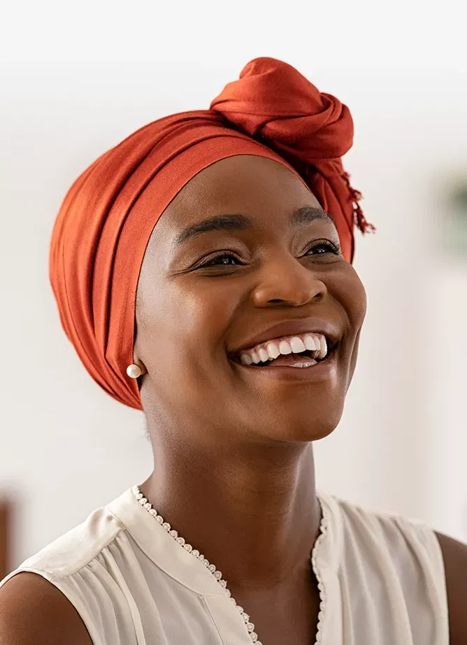 Photo of a woman wearing a head wrap and smiling