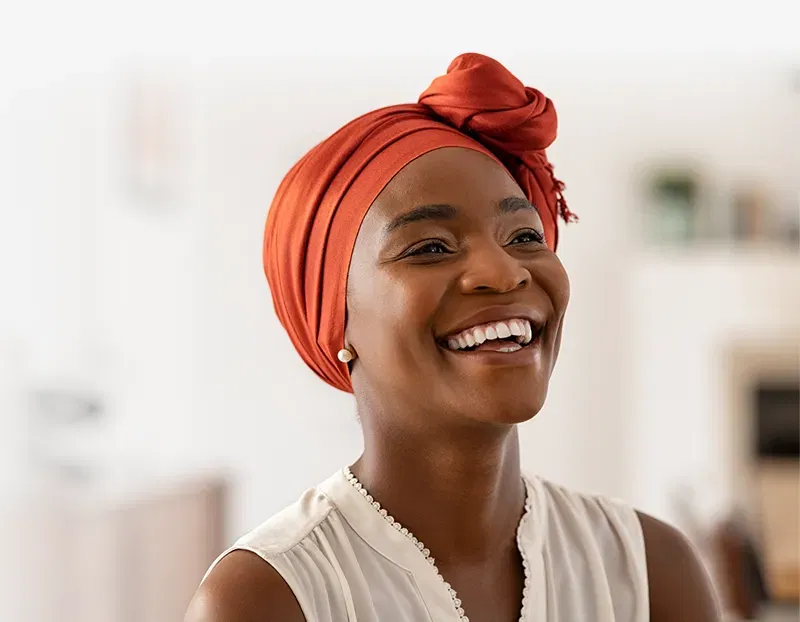 Photo of a woman wearing a head wrap and smiling